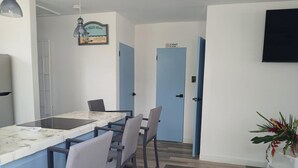 A modern kitchen with a marble countertop, a dining area with chairs, and a blue door with a 'No Smoking' sign. - 2-bedroom house in peaceful Lower Carlton w/ AC, WiFi. Within steps of the beach (Lower Carlton)
