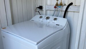 A white front-loading washing machine with a control panel and hoses. - 2-bedroom house in peaceful Lower Carlton w/ AC, WiFi. Within steps of the beach (Lower Carlton)