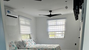 A room with two beds, a ceiling fan, and a window with blinds. - 2-bedroom house in peaceful Lower Carlton w/ AC, WiFi. Within steps of the beach (Lower Carlton)