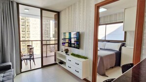 A modern apartment with a balcony, a TV, a bed, and a sofa. - COGRA0102 - Edifício Graça Prime (Salvador)
