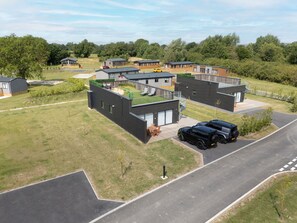 Un quartier résidentiel avec des maisons modernes, une allée pavée et une pelouse verdoyante.