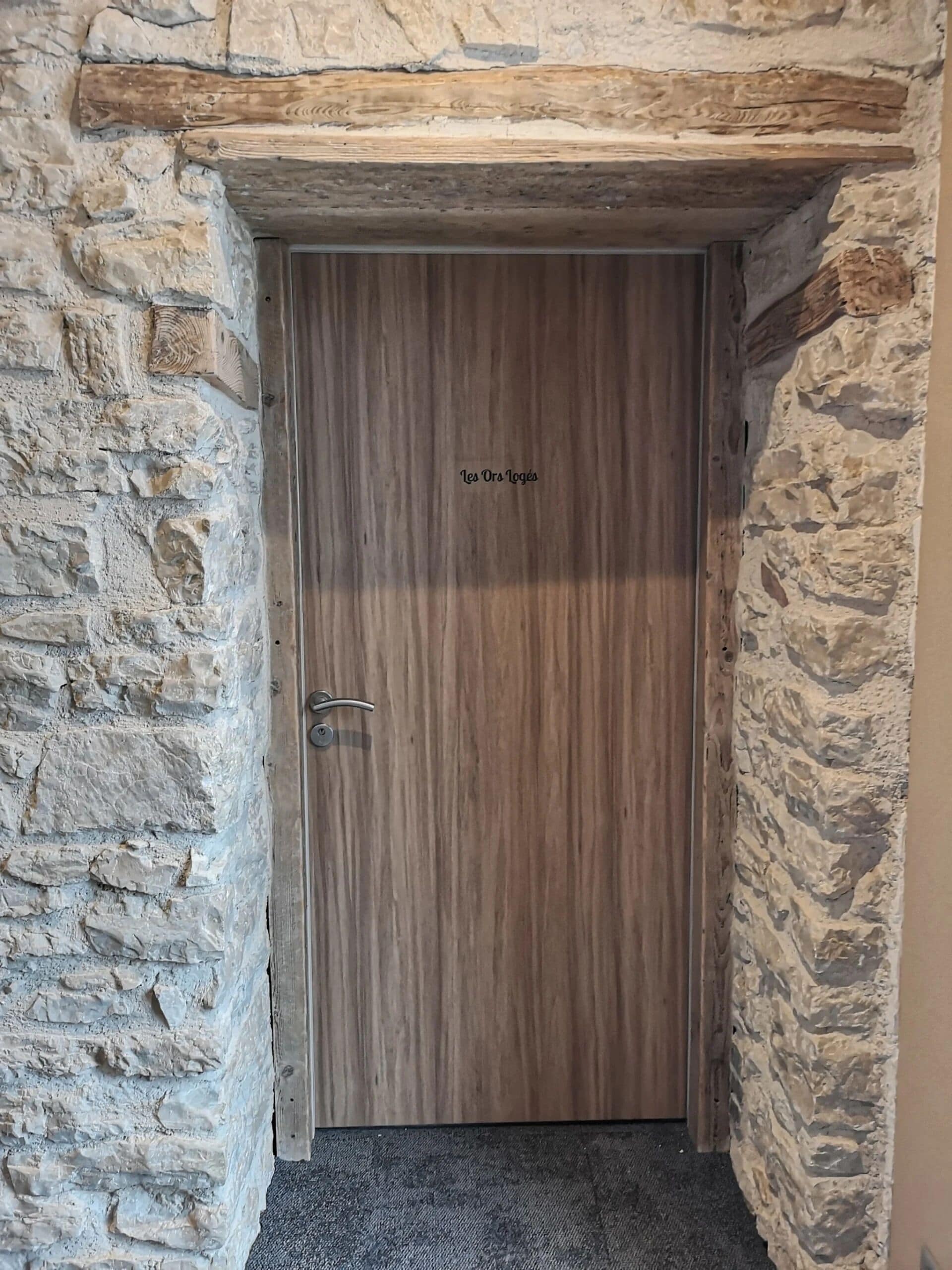 A wooden door with a stone wall on either side.