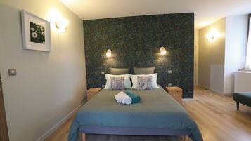Un dormitorio moderno con una cama grande, dos mesitas de noche y una pared con estampado floral.