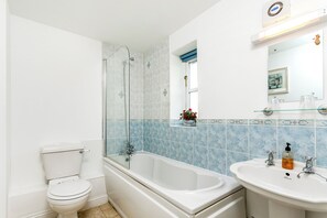 Un baño con inodoro, bañera y lavamanos.