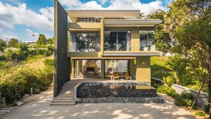 Een modern huis met twee verdiepingen en een stenen trap naar de ingang.