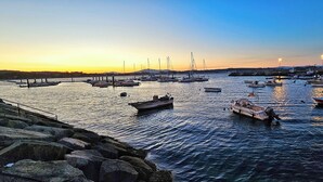 A marina with boats docked at piers, calm water, and a clear sky. - SeaView Boiro Apartment 2 Bed (Boiro)