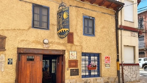 Ein Gebäude mit einem Schild, auf dem 'Albergue San Miguel' steht, und einem Krankenhaussymbol.