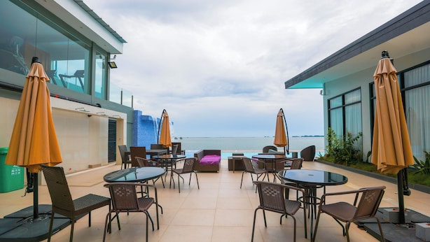 Une terrasse sur le toit avec des sièges extérieurs, une piscine et une vue sur l’océan.