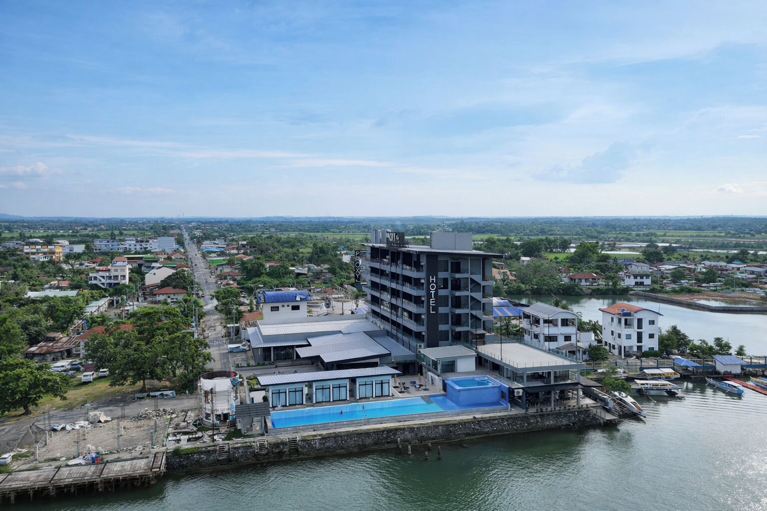 A hotel with multiple floors, a swimming pool, and a waterfront location.