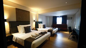 Une chambre d’hôtel avec deux lits, un bureau, une chaise et un téléviseur.
