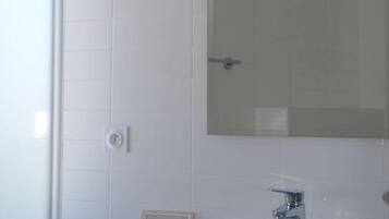 A bathroom with a white sink, a mirror, and a window.