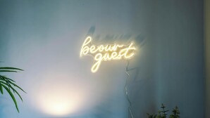 Un rètol de neó a la paret amb la frase "beour guest".