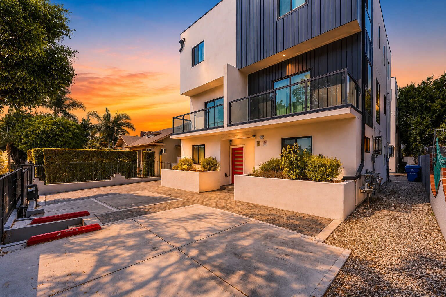A modern two-story building with a flat roof, large windows, and a balcony.
