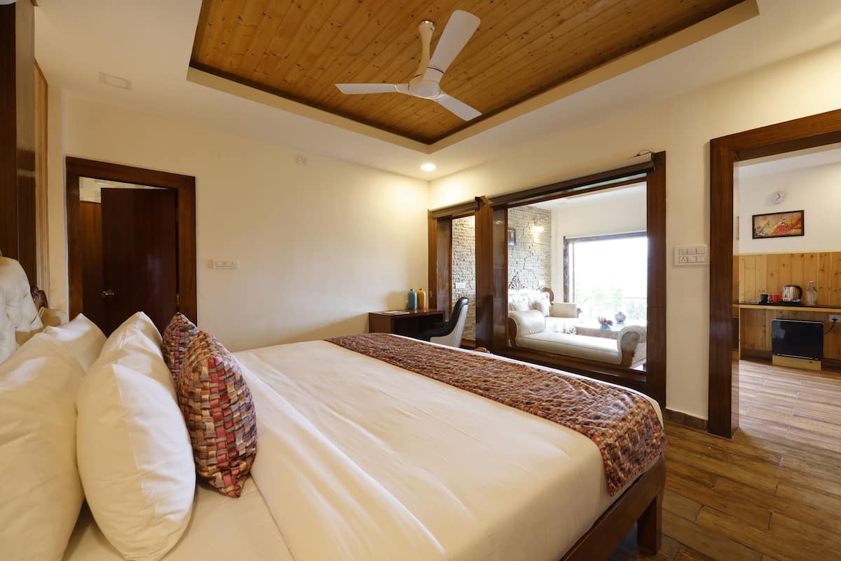 Een slaapkamer met een groot bed, houten plafond en uitzicht op het balkon.