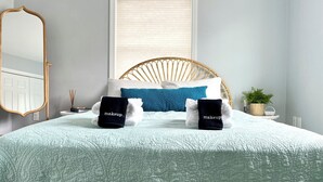 A neatly made bed with a light blue quilt, a wooden headboard, and two towels with "makeup" written on them. - Family friendly and dog welcoming home, minutes from the beach in Old Orchard! (Old Orchard Beach)