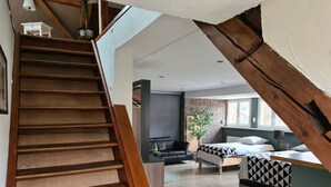 A staircase leading to a living area with a bed, a sofa, and a TV. - Au Wingenerhof (Wingen-sur-Moder)