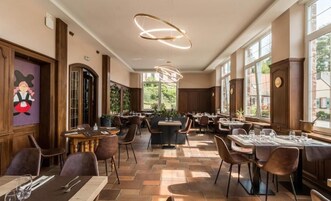Un restaurante con una decoración moderna, con paneles de madera, ventanas amplias y una combinación de mesas y cabinas.