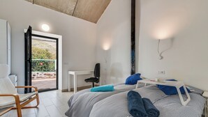 Ein modernes Schlafzimmer mit Bett, Schreibtisch und Stuhl.