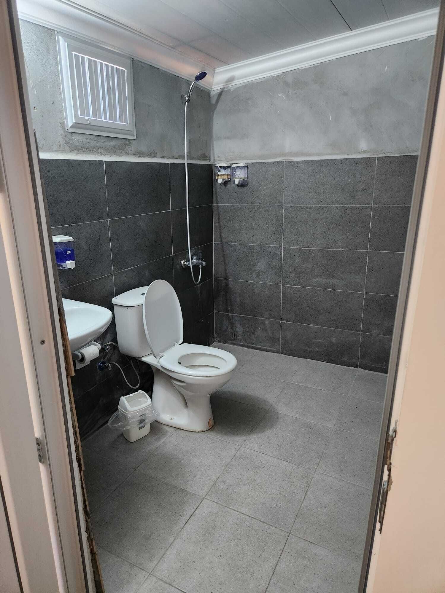 A bathroom with a toilet, sink, and shower.