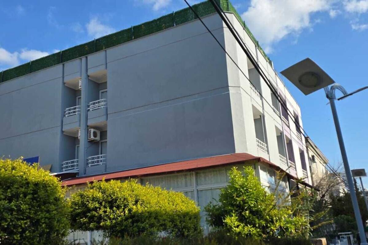 Un bâtiment moderne doté d’un toit plat, de nombreux balcons et d’un lampadaire.