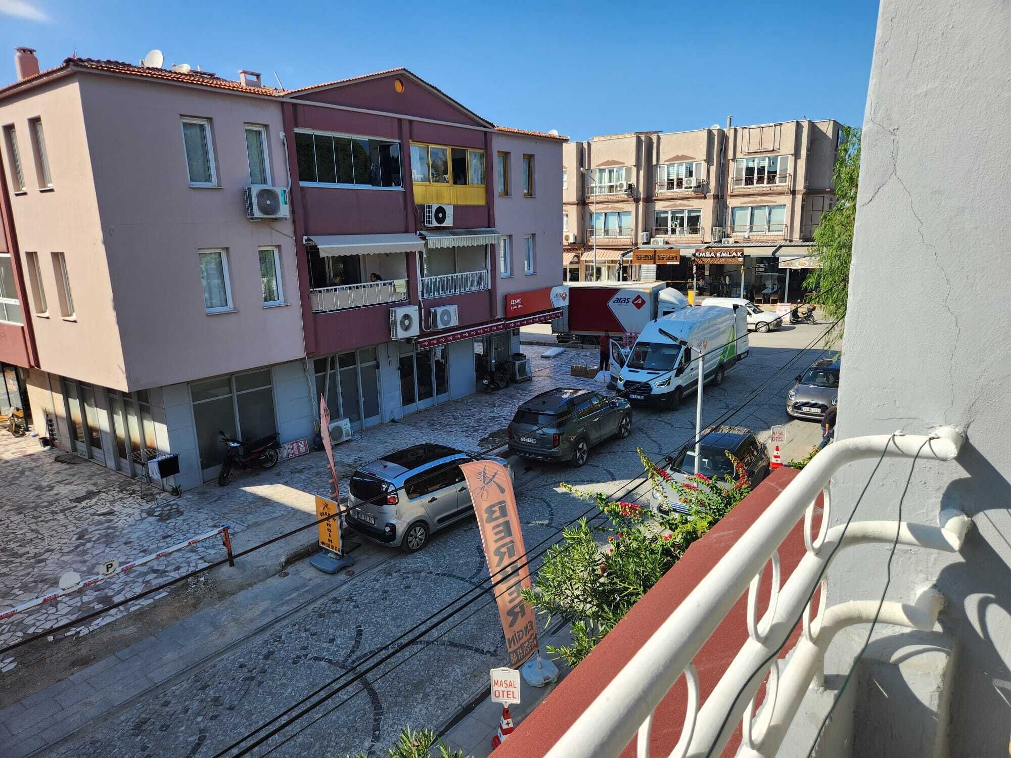 Un edificio con varios pisos, balcones y una tienda en la planta baja.
