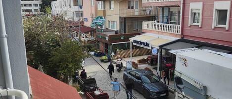 A street view with buildings, a parked truck, and a red vehicle.