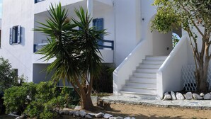 Un edificio moderno con fachada blanca, una escalera y una palmera.