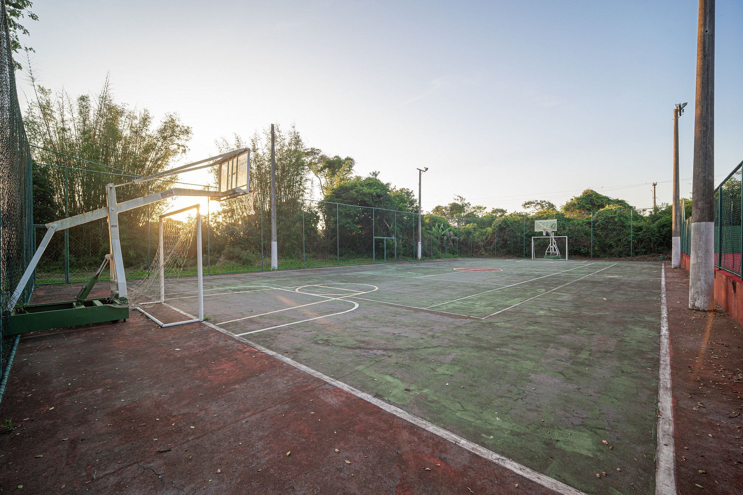 Een buitenbasketbalveld met een net, basket en een basketballmand.
