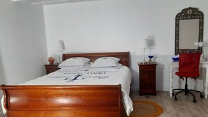 A neatly arranged bedroom with a wooden bed, a desk with a chair, a mirror, and bedside lamps. - Beautiful view (Agde)