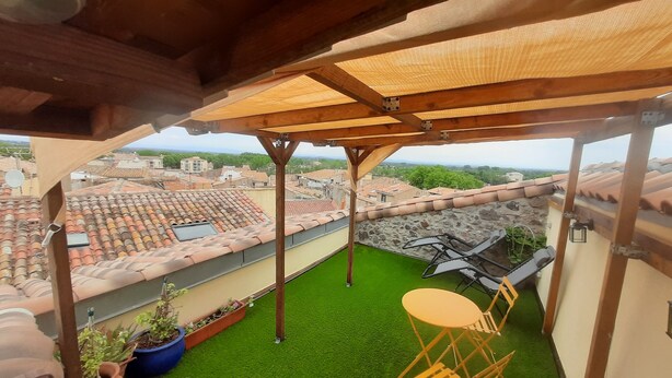 A rooftop terrace with a wooden pergola, green artificial turf, and a small table and chair. - Beautiful view (Agde)