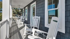 A porch with white rocking chairs and a white railing. - Ocean & Sound Views, Elevator, Close to Beach & Dining! (Wrightsville Beach)