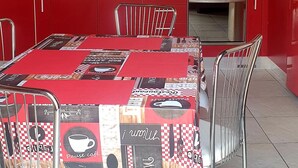 A compact kitchen with red cabinets, a stainless steel stove, and a microwave. - Cozy and quiet apartment in ideal location in Reggio Cal. (Reggio Calabria)