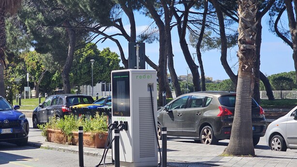 A parking area with electric vehicle charging stations, trees, and parked cars. - Cozy and quiet apartment in ideal location in Reggio Cal. (Reggio Calabria)