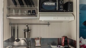 Cocina compacta con microondas, tostadora y pileta.