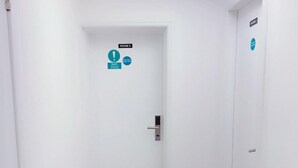 En hall med trägolv, en dörr märkt med "RUM 3" och en skylt som visar "Branddörr – håll stängd".