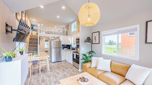 Un espacio habitable amplio con un sofá, una mesa de comedor y una cocina al fondo.