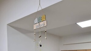 Een moderne keuken met houten kastjes, een marmeren aanrechtblad en een hangend welkomstbord.