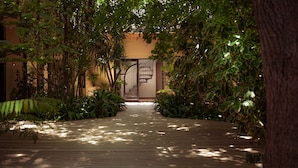 A wooden pathway leading to a spiral staircase surrounded by lush greenery. - Botany House Boutique Retreat (Cape Town)