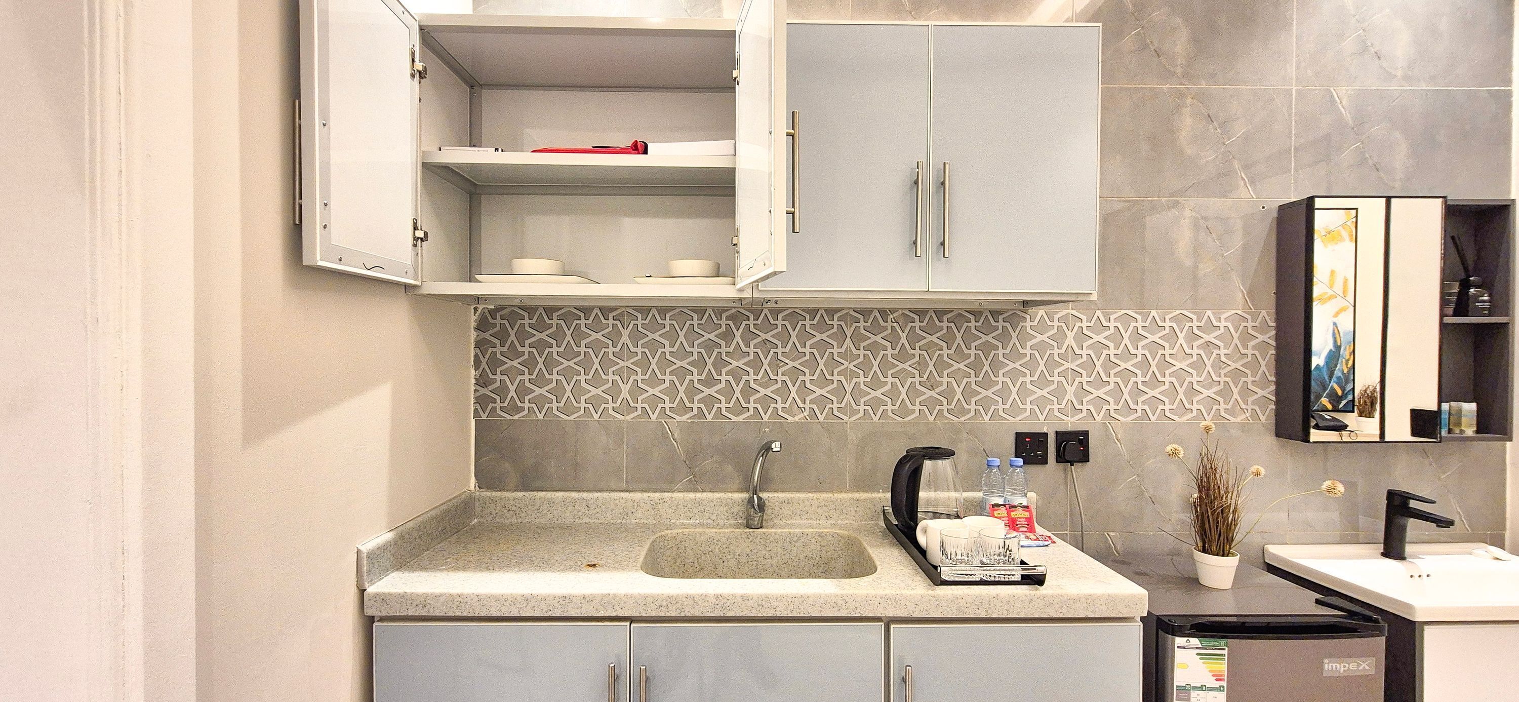 A modern kitchen with a granite countertop, a built-in sink, and a coffee machine.