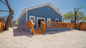 A blue building with a wooden deck and steps leading to the entrance.