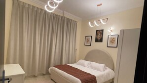 Een moderne slaapkamer met een bed, een bureau en een kledingkast.
