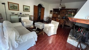 A living room with a fireplace, a dining area, and a kitchen. - The tranquility of the Umbrian countryside a stone's throw from the center of Perugia (Umbria)