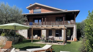 A two-story house with a stone exterior, a balcony, a pool, and outdoor furniture. - The tranquility of the Umbrian countryside a stone's throw from the center of Perugia (Umbria)