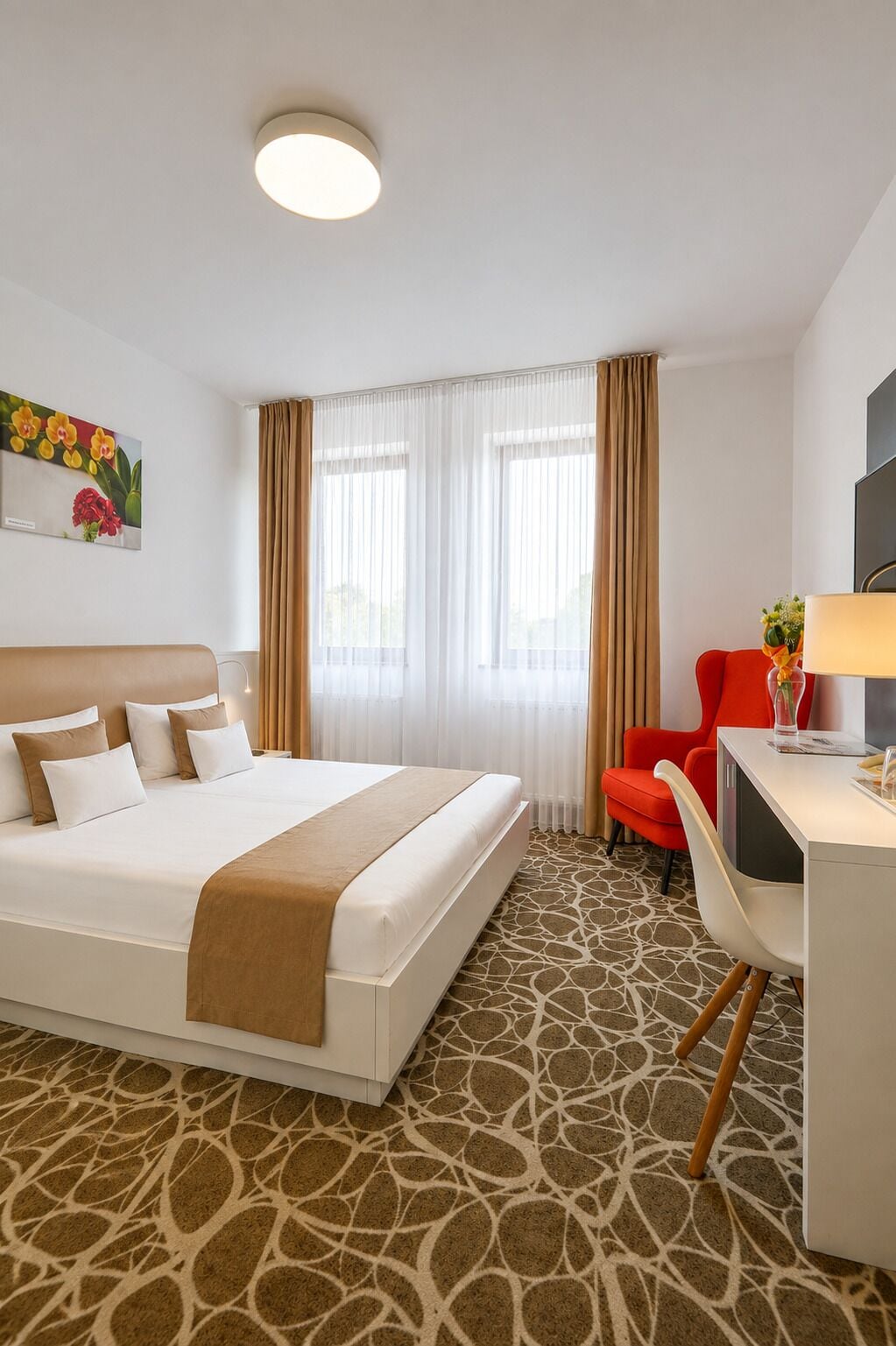 Una habitación de hotel con una cama, un escritorio y una silla.