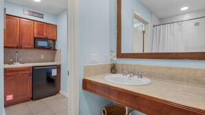 A kitchen with wooden cabinets, a microwave, and a dishwasher. - Quaint Efficiency Suite-Sleeps 4-Resort Amenities (Miramar Beach)