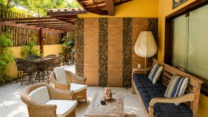 Un patio al aire libre con muebles de mimbre, una mesa y un sofá.