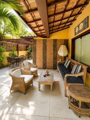 Un patio al aire libre con muebles de mimbre, una mesa y un sofá.