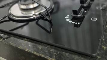 Una estufa a gas con cuatro hornillas y una perilla de control.