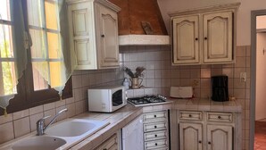 Una cocina funcional con lavamanos, microondas, estufa y armarios.