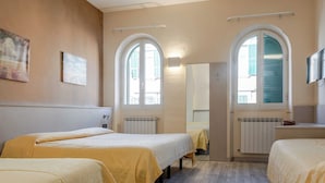 A hotel room with two beds, a large mirror, and a television.